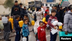 Palestinska djeca čekaju u redu za prikupljanje vode uslijed nestašice vode u Rafi na jugu Pojasa Gaze, 5. decembra