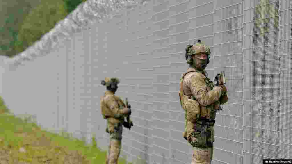 Latvian State Border Guard special unit officers patrol along the fence at the Belarusian border near Robeznieki. Riga has accused the Belarusian security forces of damaging the border fence and allowing four migrants to illegally cross in what it has referred to as "another provocation."