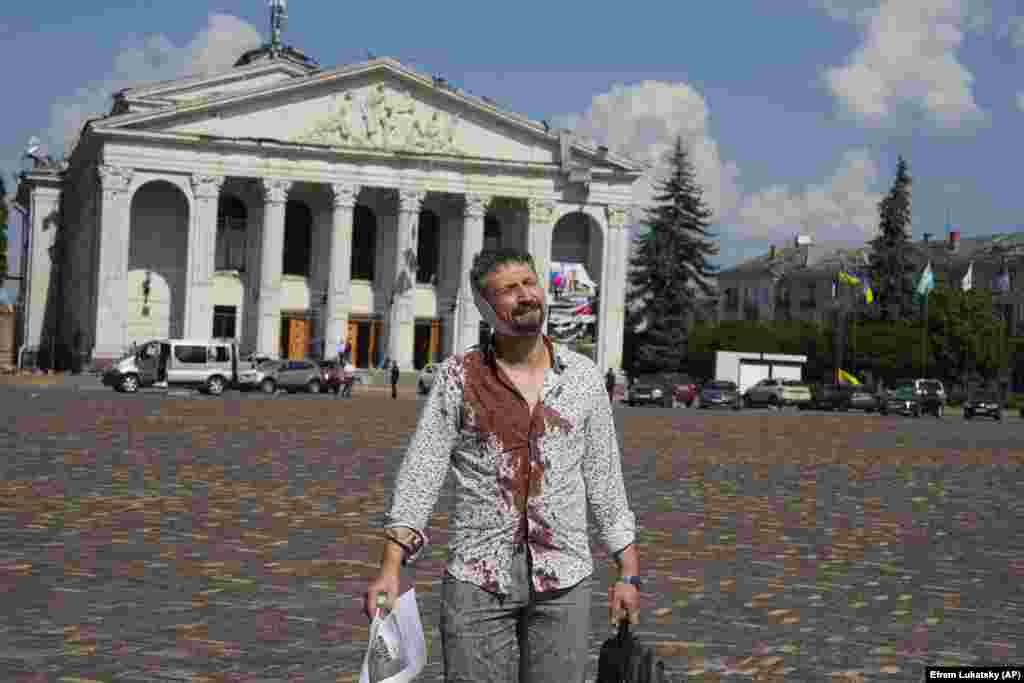 Ukrainanyň Çernihow şäherine edilen rus hüjüminde ýaralanan adam Taras Şewçenko adyndaky Çernihow sebit akademiki aýdym-saz we drama teatrynyň öňündäki Krasna meýdançasyndan ýöräp barýar.&nbsp;2023-nji ýylyň 19-njy awgusty.&nbsp;(AP/Efrem Lukatsky)