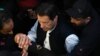 Security personnel escort former Pakistani Prime Minister Imran Khan as he arrives at the high court in Lahore on March 17.