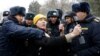 Корреспондент "Азаттыка" в окружении сотрудников милиции во время освещения акции протеста в Бишкеке. Январь 2023 года. 