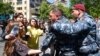 Police officers are seen detaining protesters attempting to block streets in Yerevan on May 17.