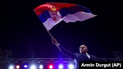 Bosnian Serb leader Milorad Dodik waves the Serbian flag to thousands who gathered in Banja Luka, Bosnia, on October 25.