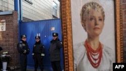 A supporter of Yulia Tymoshenko holds her portrait during a rally in front of the Kyiv prison where she is incarcerated on November 27.