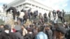 Митингчилер Ак үйдүн тосмосунан ашып түшүүдө. 3-октябрь, 2012.