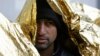 A migrant, wrapped in a thermal blanket, waits in line to get food at a migrant center in Bihac, Bosnia, close to the border with Croatia, on November 28.