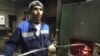 Tajik-born migrant Nazim Soliev stokes the fire at a school in Rozhdestveno, Russia