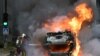 Vatrogasac gasi zapaljeni automobil u pariškom predgrađu Nanterre, 29. juna 2023.