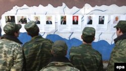 Soldaţi abhazi în faţa unui panou cu candidaţii la preşedinţie