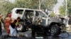 Rescue personnel inspect a vehicle damaged by a suicide bomber that killed a senior Pakistani police official on his way to work in Peshawar on November 24.