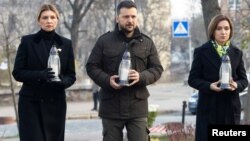 Ukraine's President Volodymyr Zelenskiy (center), his wife, Olena (left), and Moldova's President Maia Sandu mark the 10th anniversary of the Euromaidan protests in Kyiv on November 21.