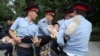 Kazakh police detain a woman during an opposition rally on June 12.