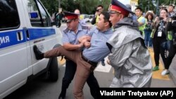 Kazakh police detain a demonstrator in Almaty on June 12.