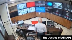 A guard looks at surveillance screens during a previous cyberattack at Evin prison in Tehran in 2021.