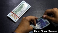 A currency trader counts Pakistani rupee notes as he prepares an exchange of U.S dollars in Islamabad.