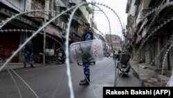 Indian security forces stand guard at a roadblock ahead of Muslim Friday Prayers in Jammu in the Kashmir region on August 9. 