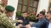 Прикордонник (ліворуч) подає протокол про адміністративне правопорушення колишньому грузинському президенту Міхеїлу Саакашвілі (в центрі) біля готелю у Львові, 12 вересня 2017 року