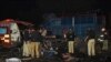 Pakistani policemen and volunteers move the bodies of victims at the site of a bomb explosion in Lahore on February 13. 