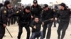 Police take away a man from the scene of the January 19 protest over rent hikes at the Bina shopping center in Baku.