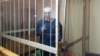 Бандарэнка на закратаванай лаве падсудных паказвае знак «Перамога»