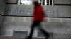 A man walks past graffiti in the Serbian capital, Belgrade, that reads "Never in EU."